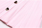 Macro of pleated hem and buttons on pink dress