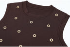 Close-up on brown knit tank with gold circular embellishments