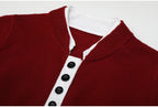 Close-up of wine red knit top with white button placket