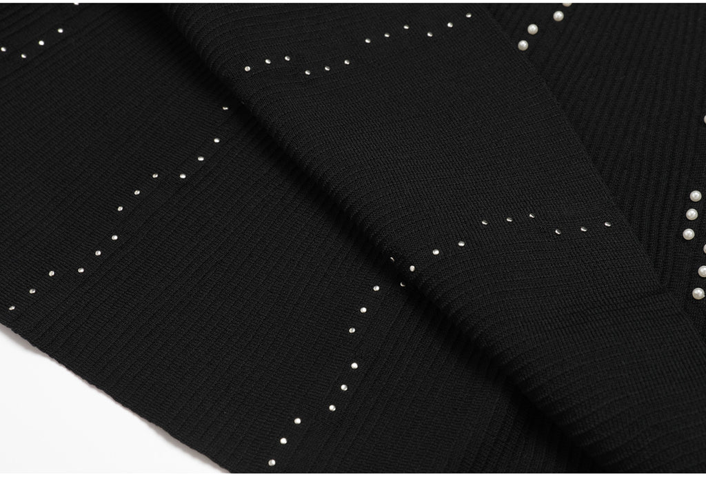 Close up of black knit fabric with pearl embellishments