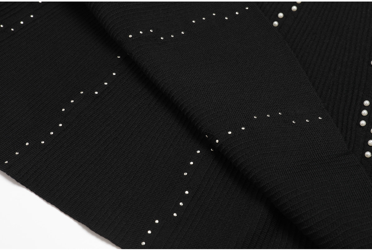 Close up of black knit fabric with pearl embellishments