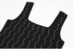 Shoulder and neckline details of black knit dress with pearls
