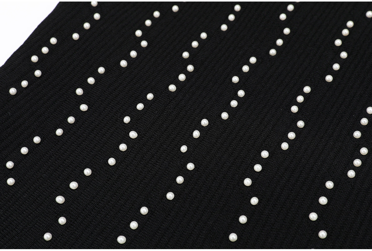 Detailed pattern of pearls on black ribbed knit fabric